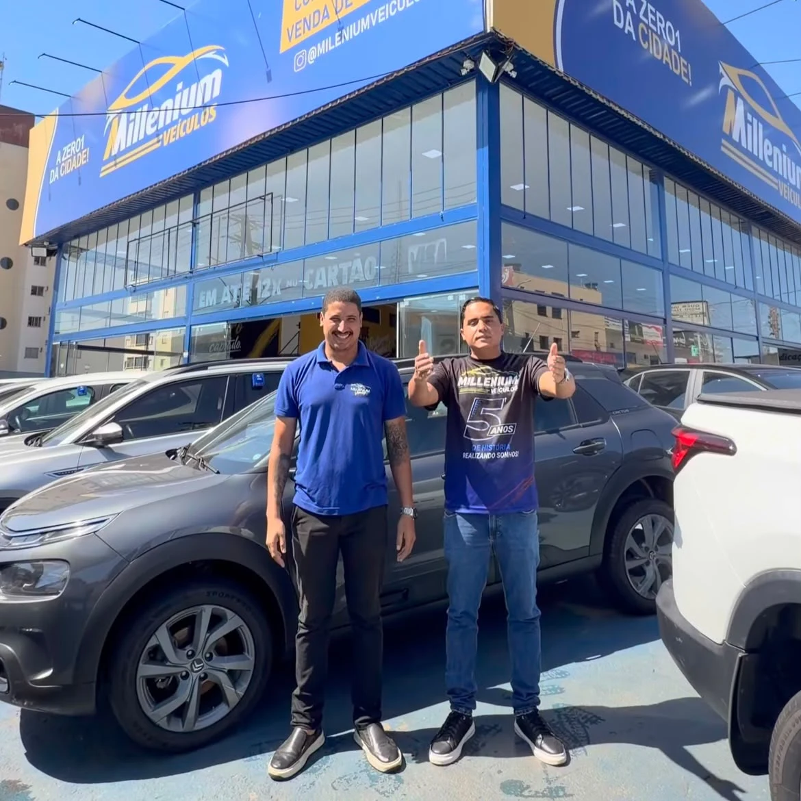 Equipe e cliente em frente à Millenium Veículos